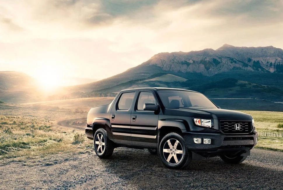 honda ridgeline parked in a field with mountains in the background