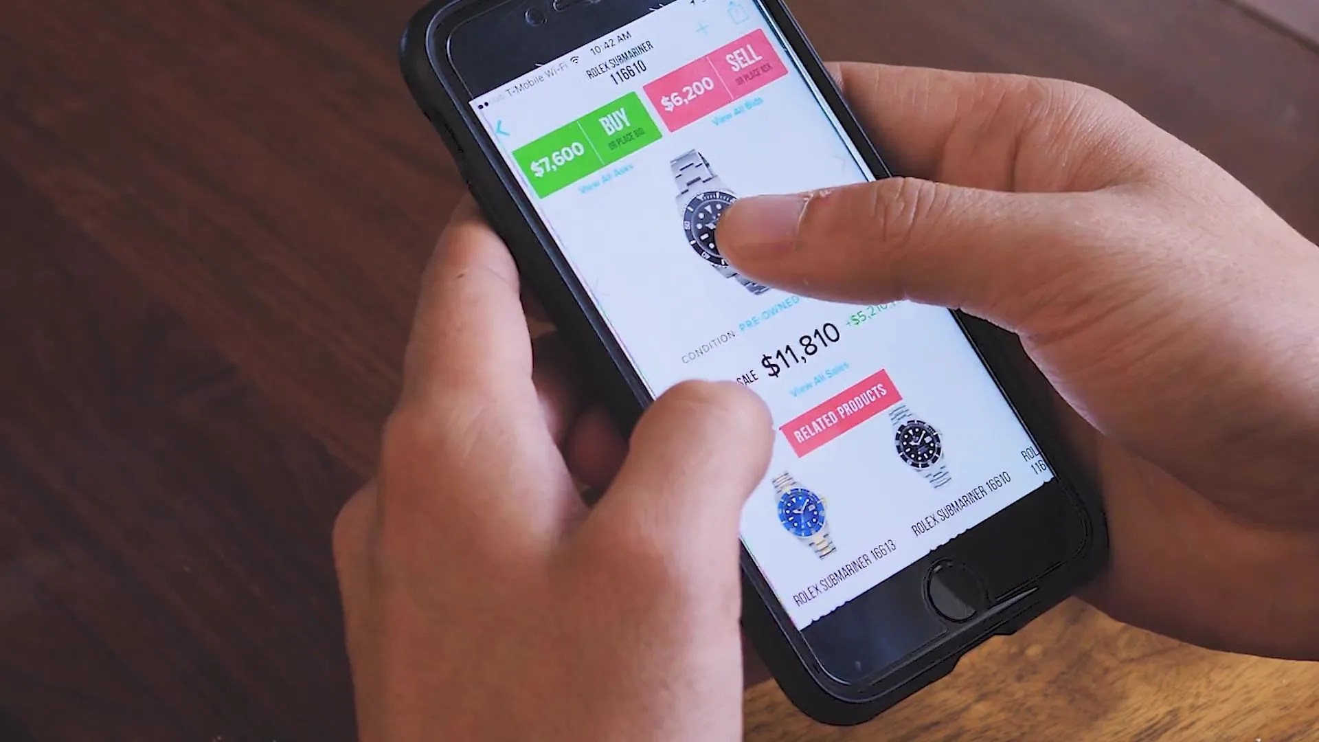 hands holding a phone and tapping on a picture of a watch within the stockx app