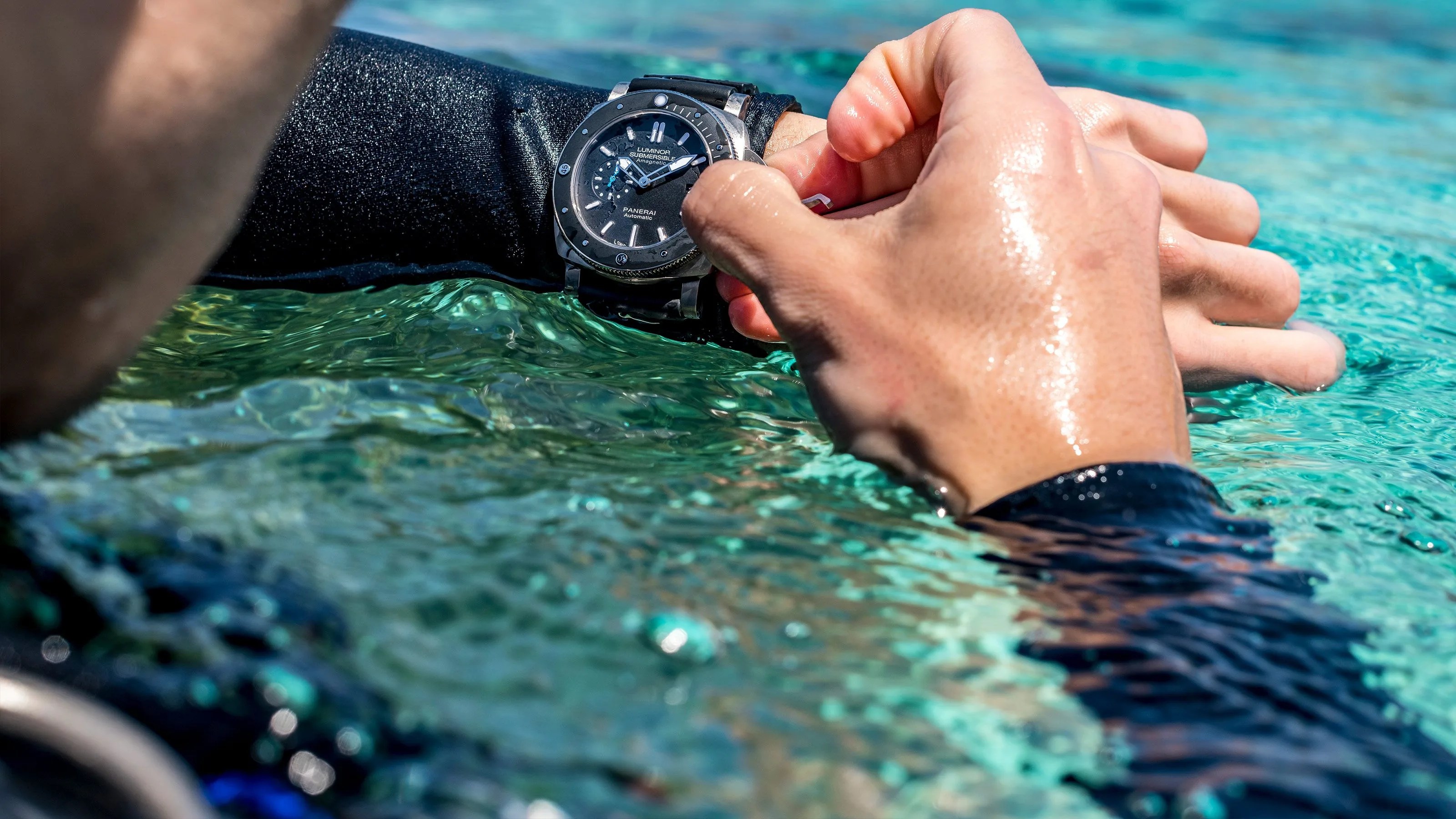 man turning dial on panerai watch in the water