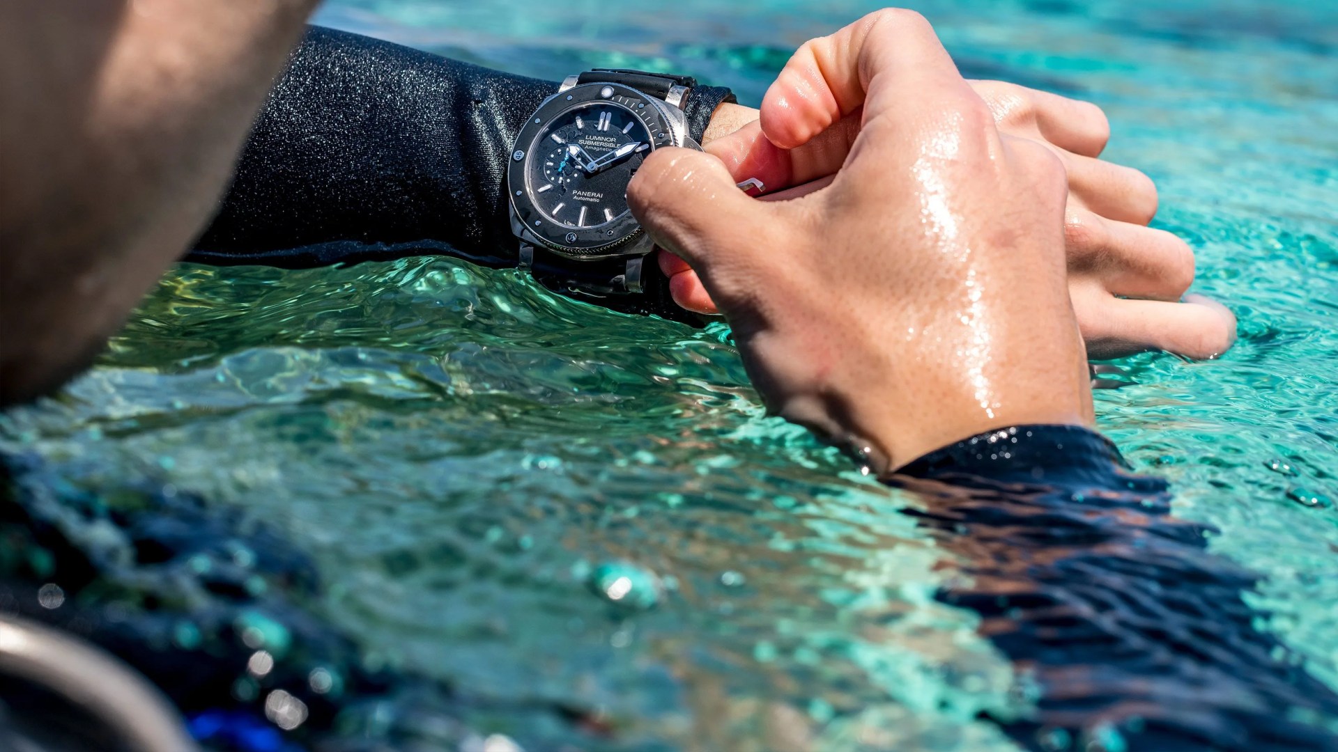 man turning dial on panerai watch in the water