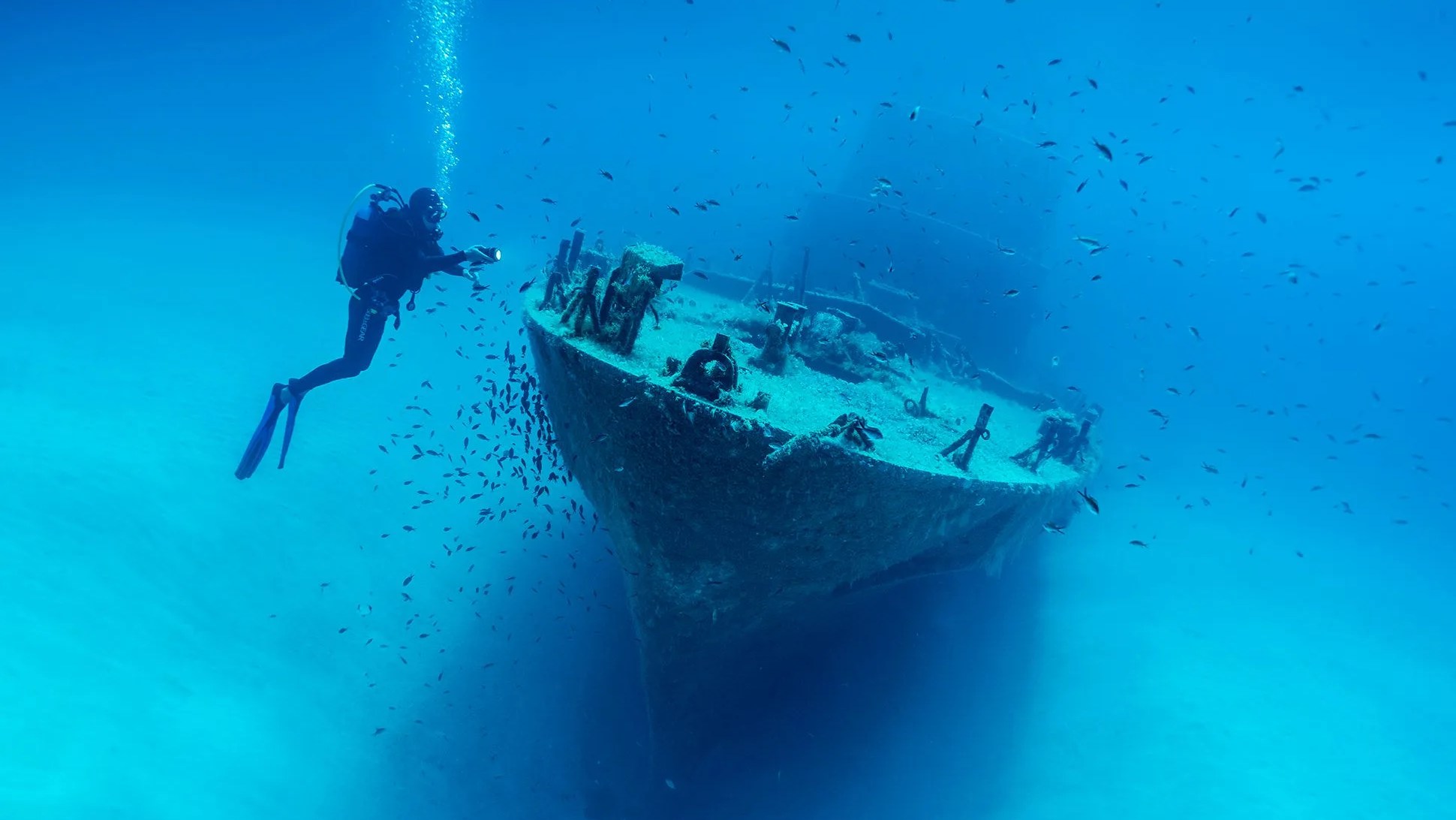 man diving by shipwreck