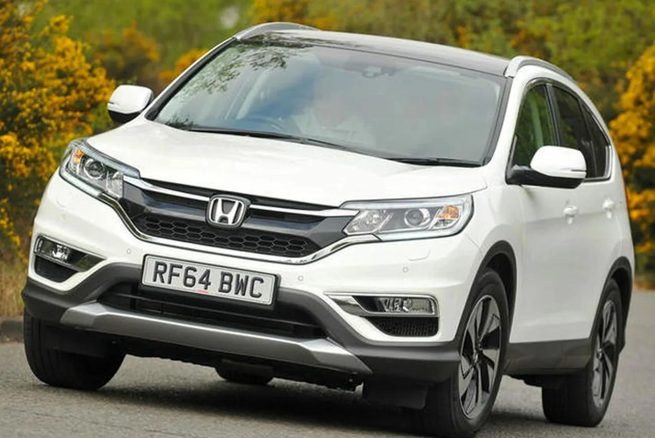 honda cr v driving on road with trees in background