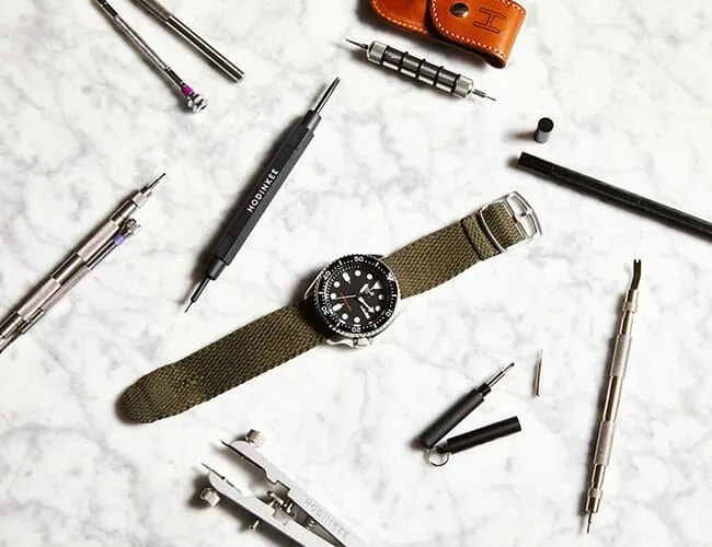 seiko watch on a marble table next to spring bar tools
