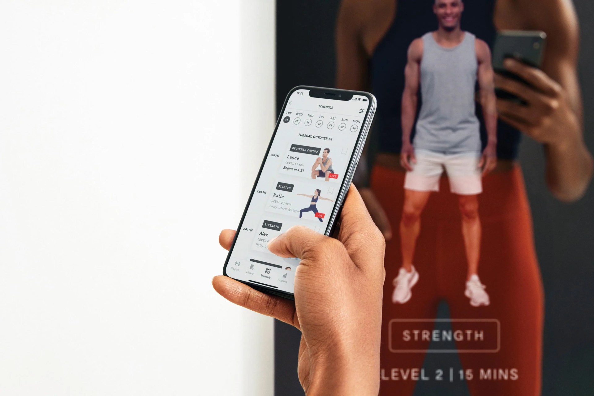 person holding their smartphone displaying the mirror fitness app