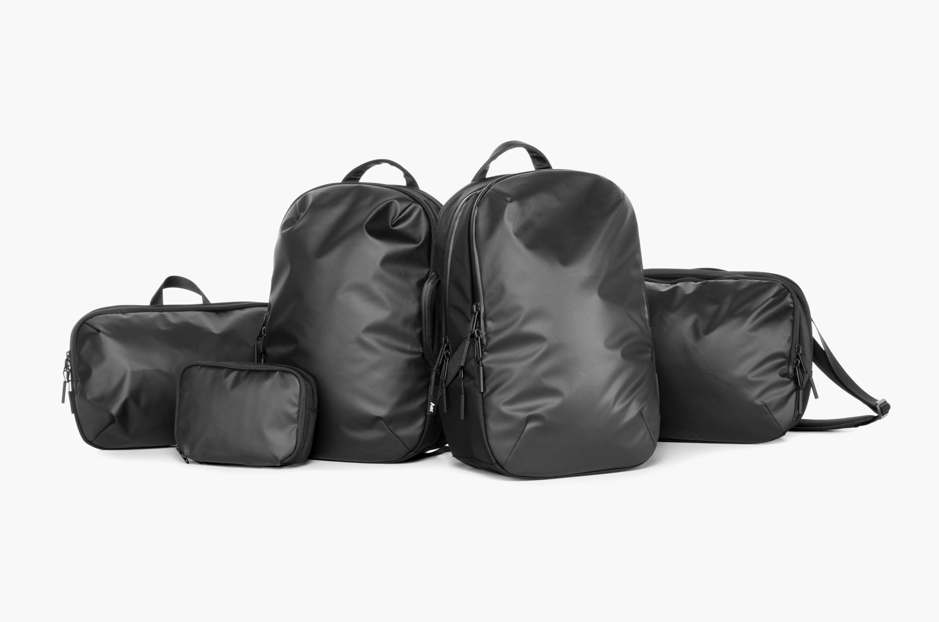 a pile of various black aer packs such as backpacks, laptop bags, etc