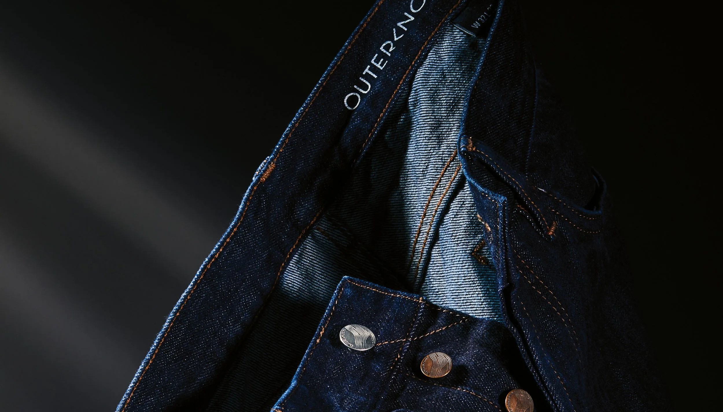 a hanging pair of outerknown denim jeans