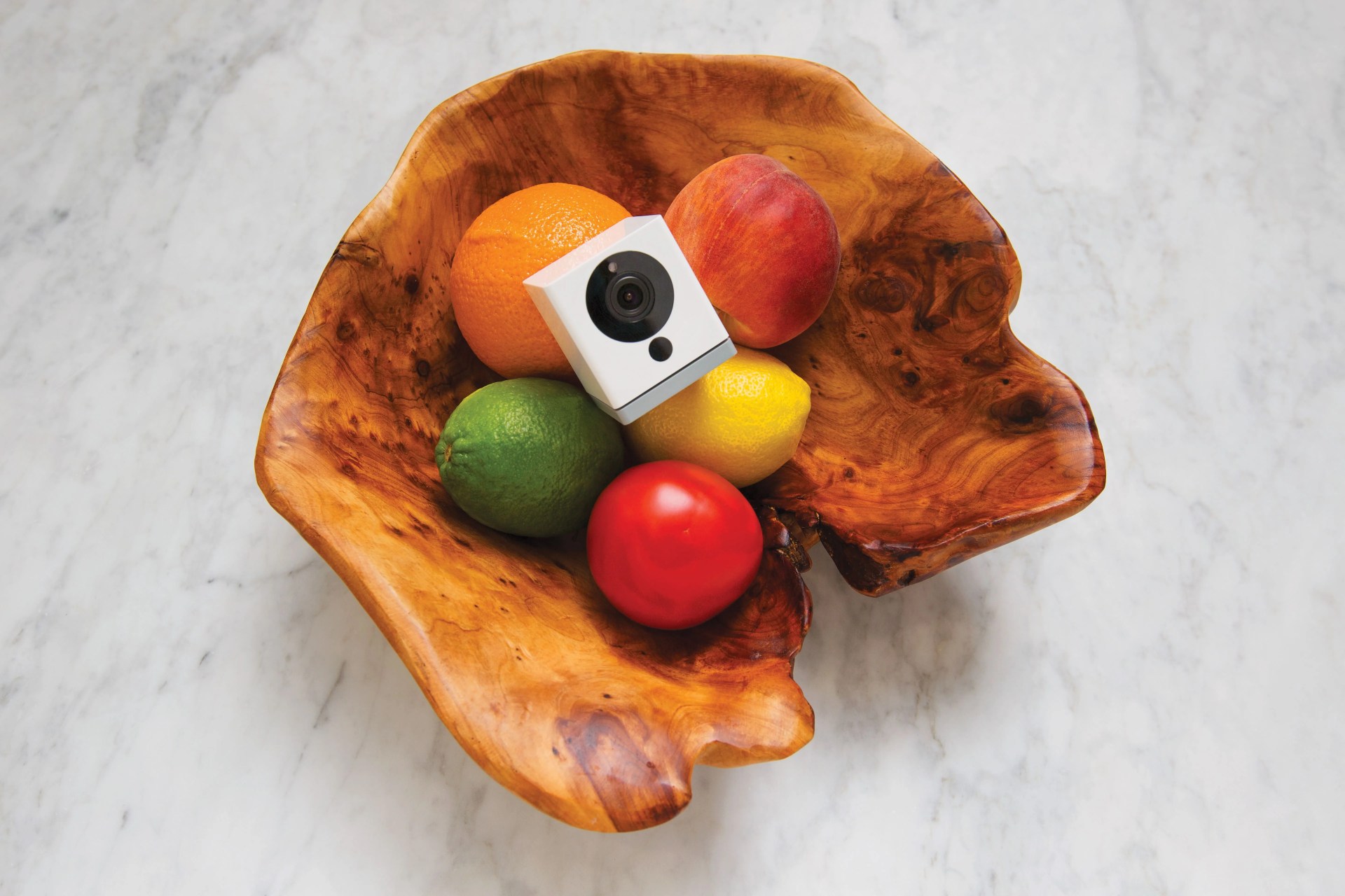 wyze cam camera laying in a bowl of fruit