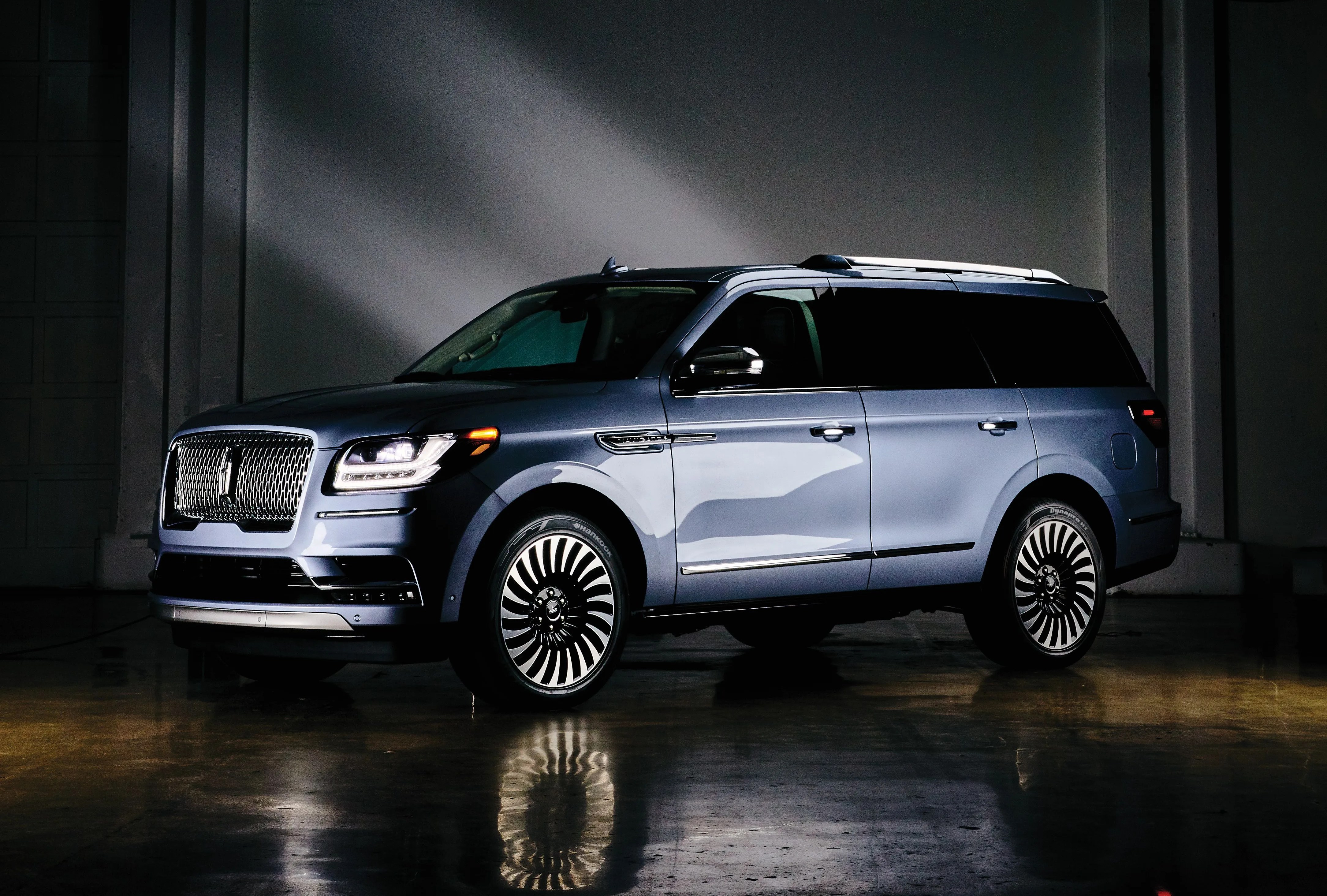 light blue lincoln navigator car parked sideways