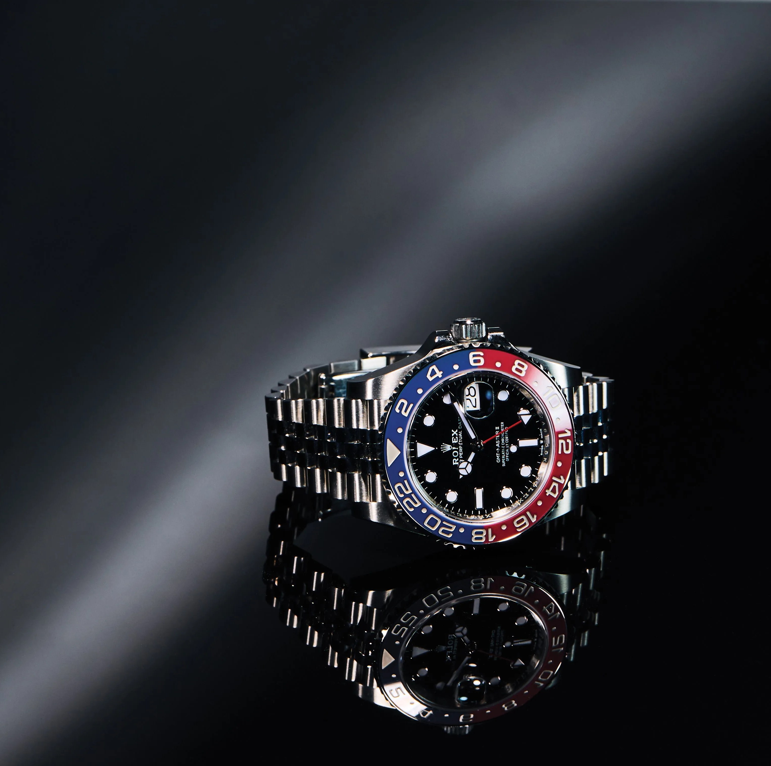 rolex gmt pepsi bezel watch with a silver bracelet