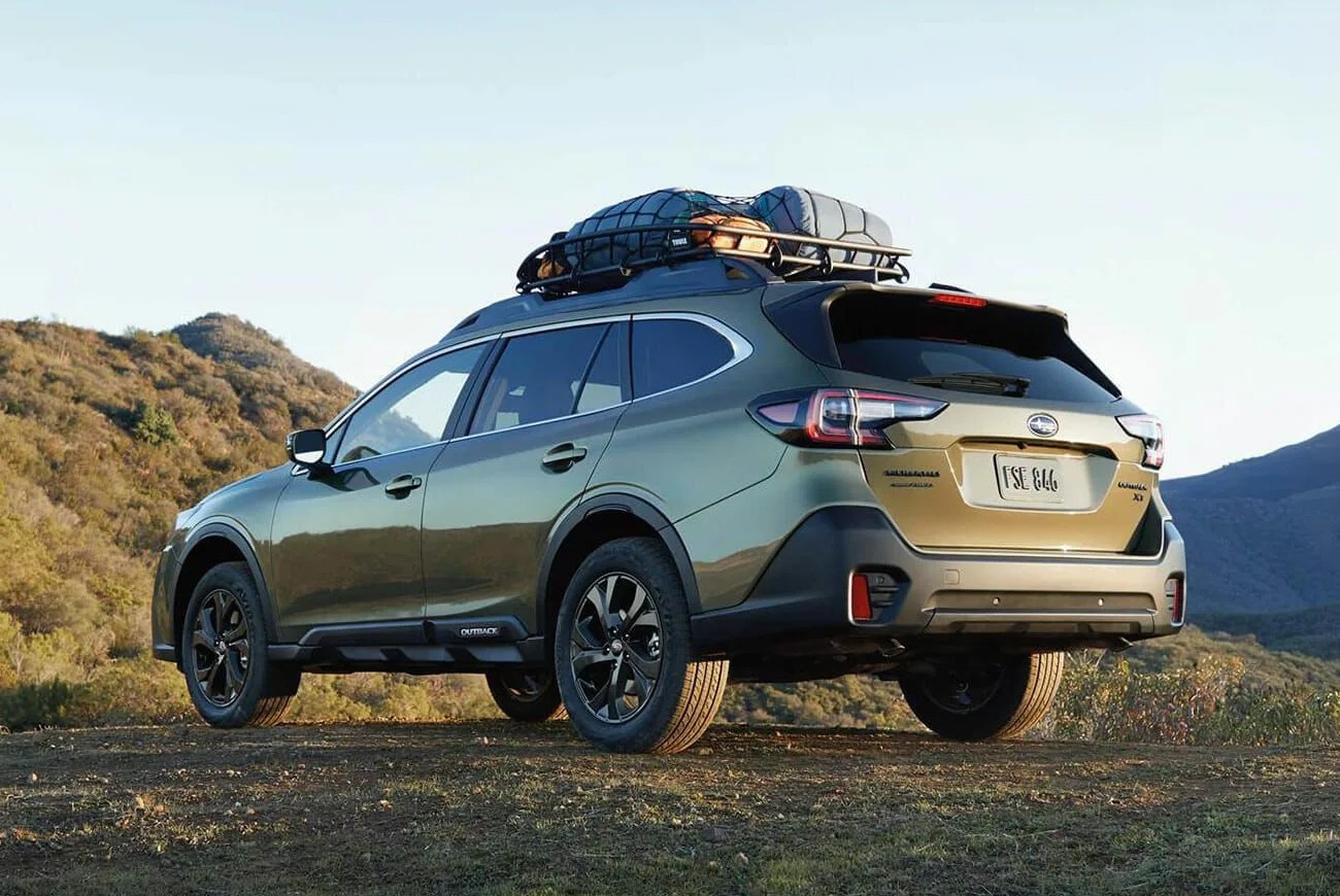 subaru outback parked on a dirt road with a rooftop cargo carrier