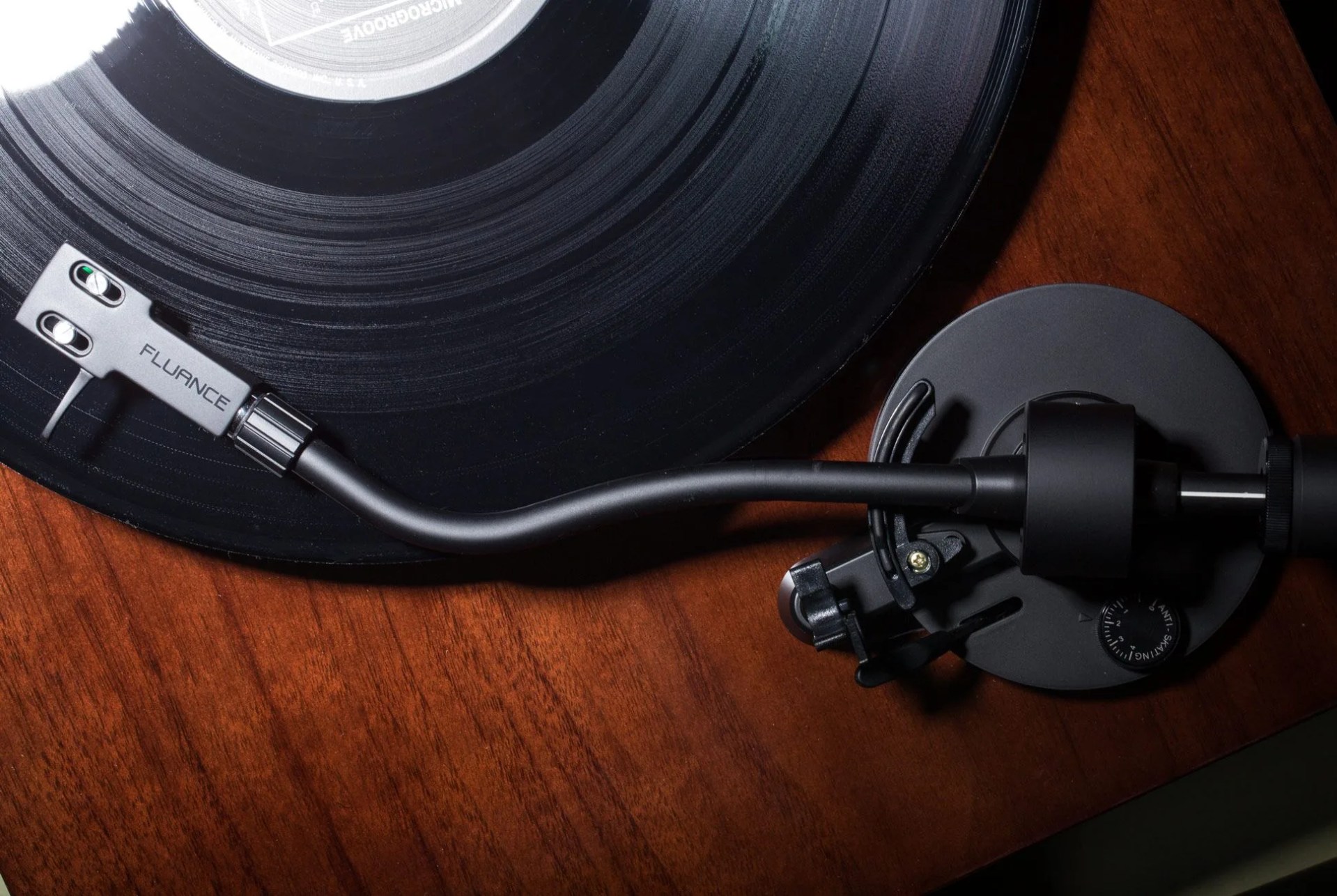 turntable arm and cartridge on a walnut background