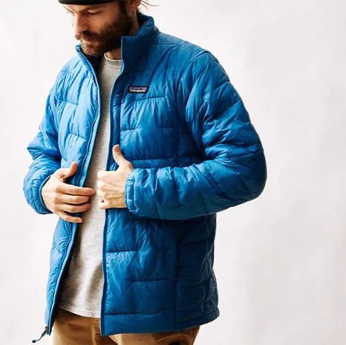 a man wearing a blue patagonia puffy jacket on a blank background