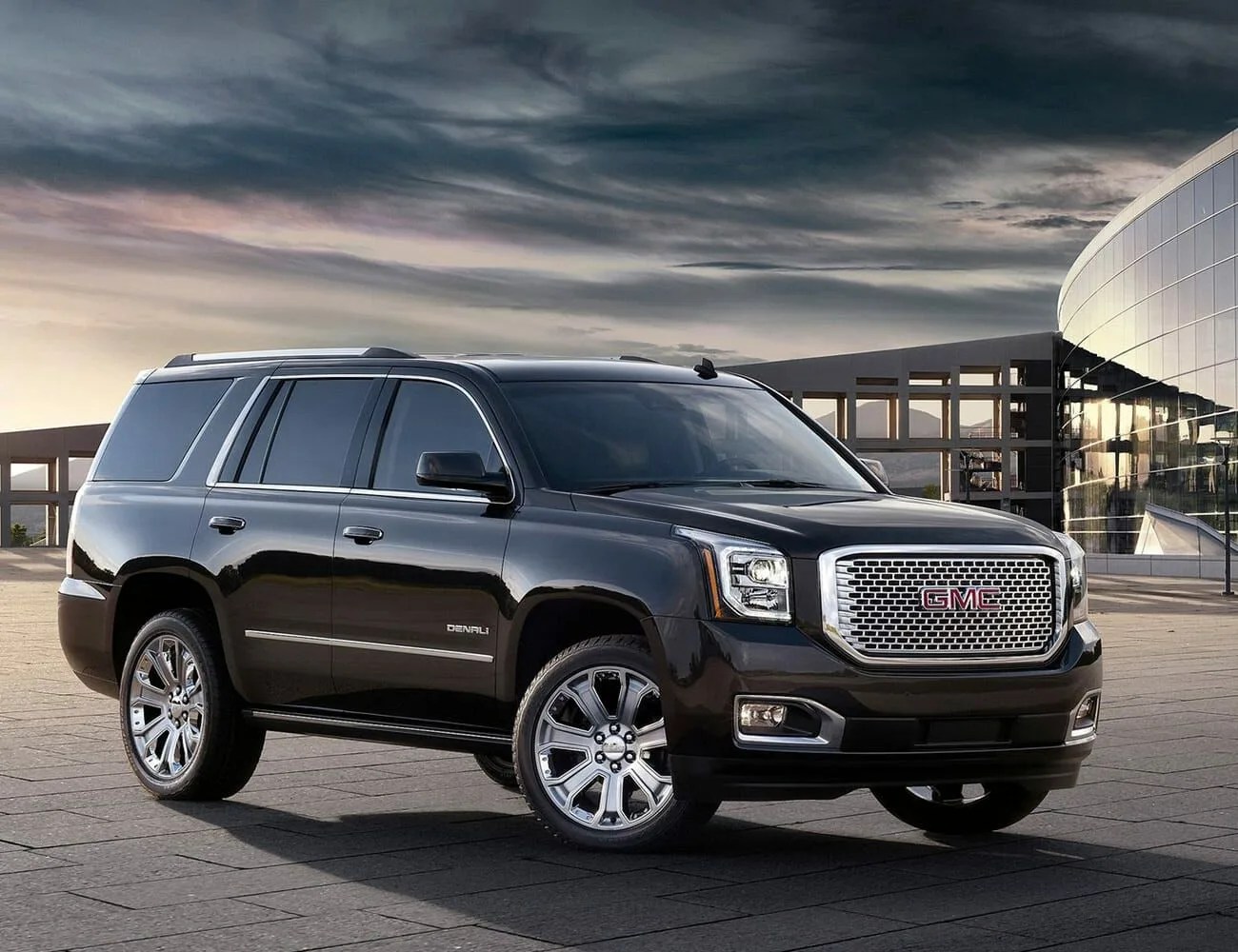 gmc yukon parked in front of a modernist glass building