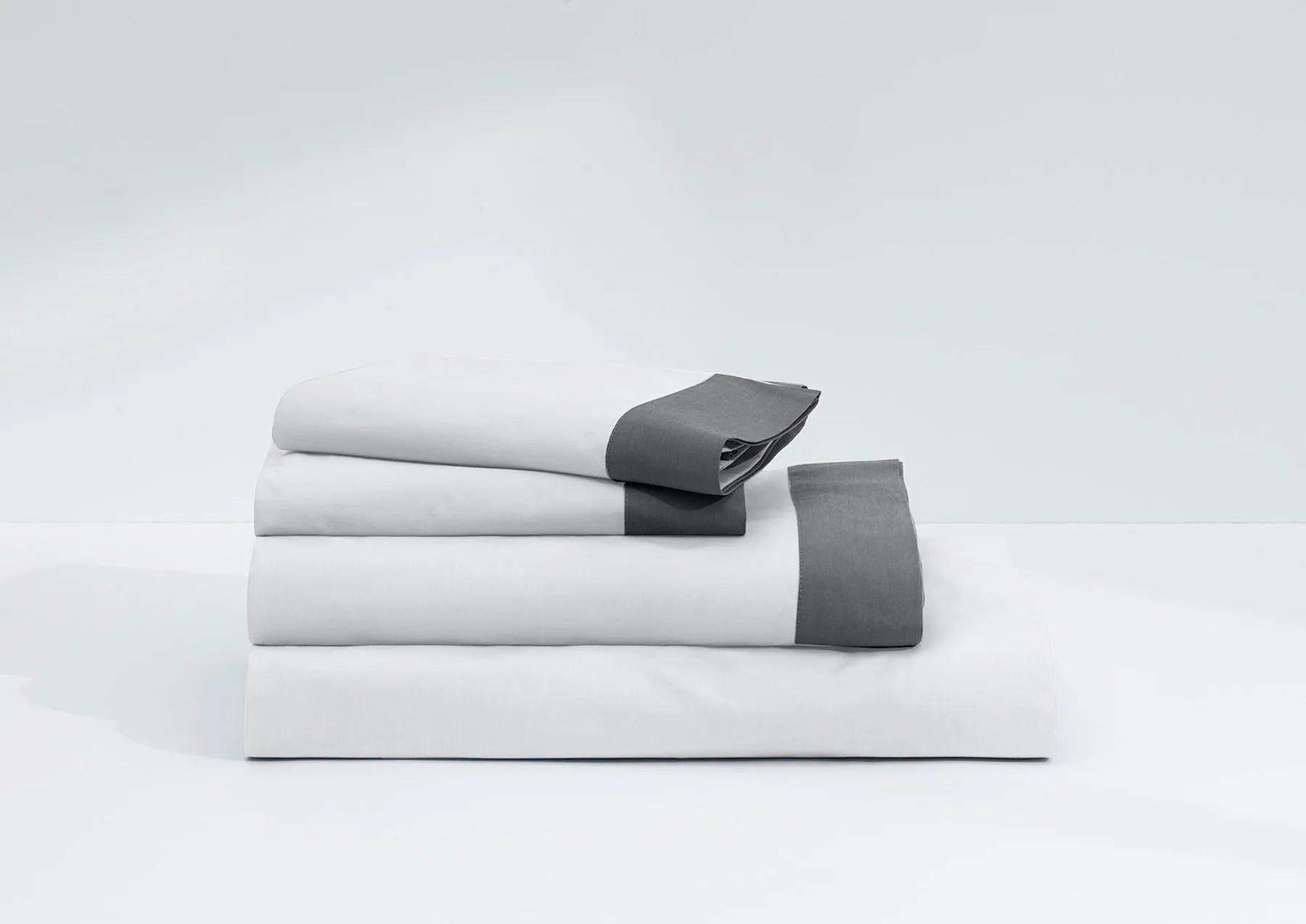 White and gray bed sheet set on a white background.