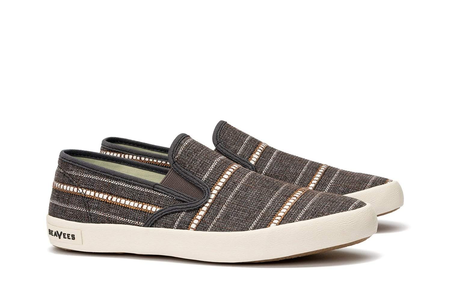 Brown striped slip on sneakers on a white background.
