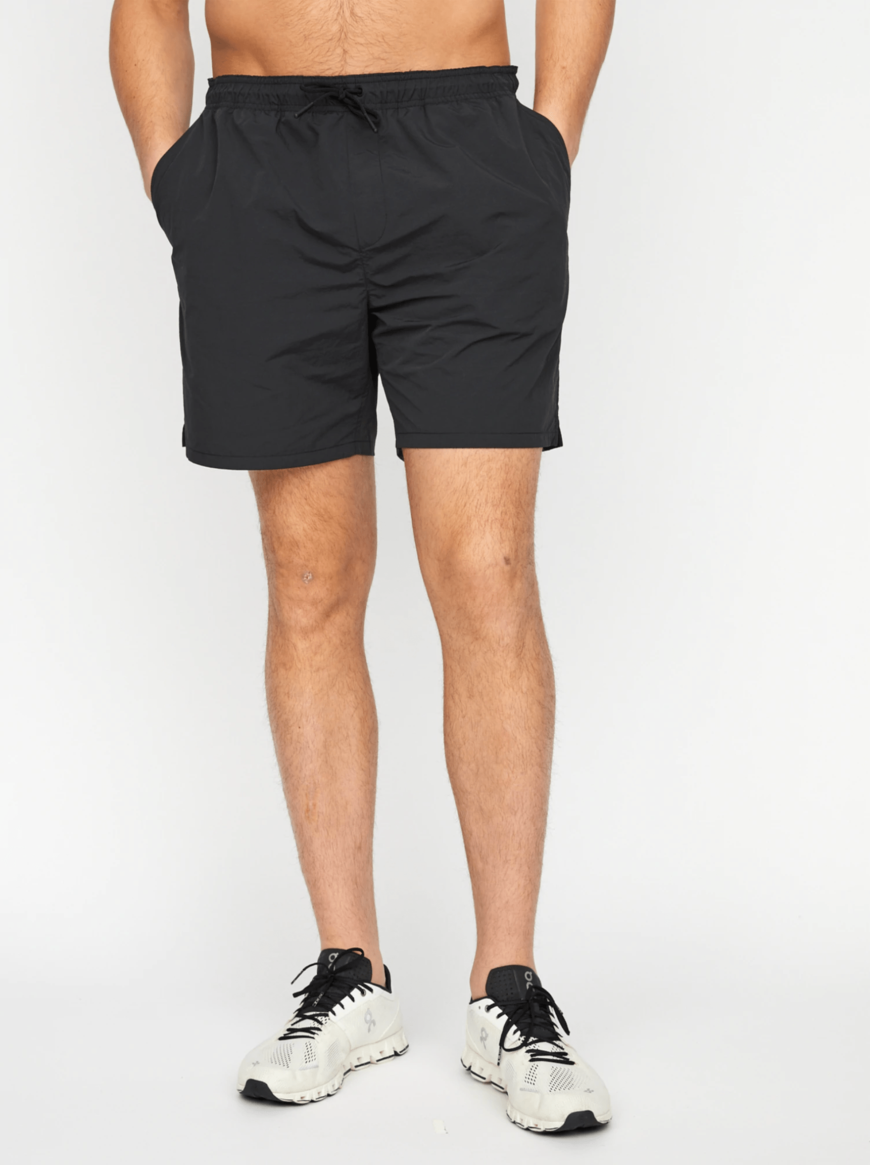 Black elastic shorts on a model on a white background.