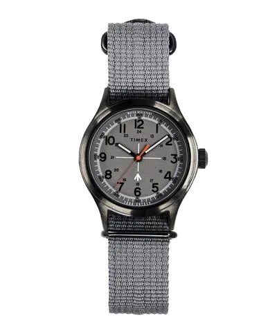 A grey Timex and Todd Snyder field watch with a cloth strap.
