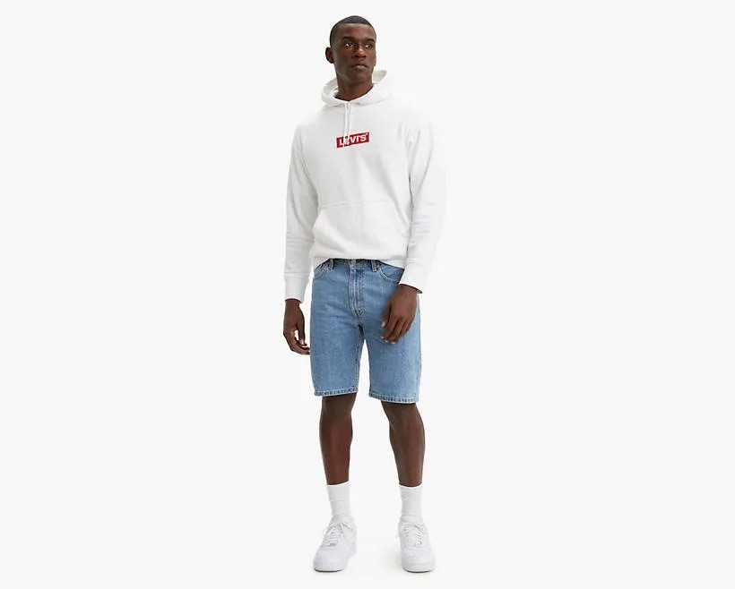 model wearing denim shorts, white hoodie, white sneakers