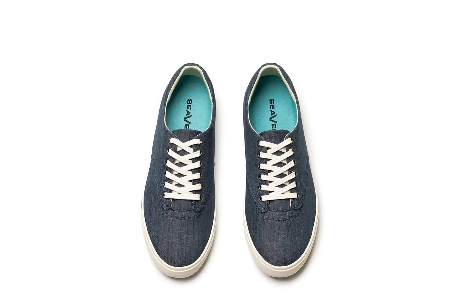 Chambray sneakers with white laces and soles on a white background.