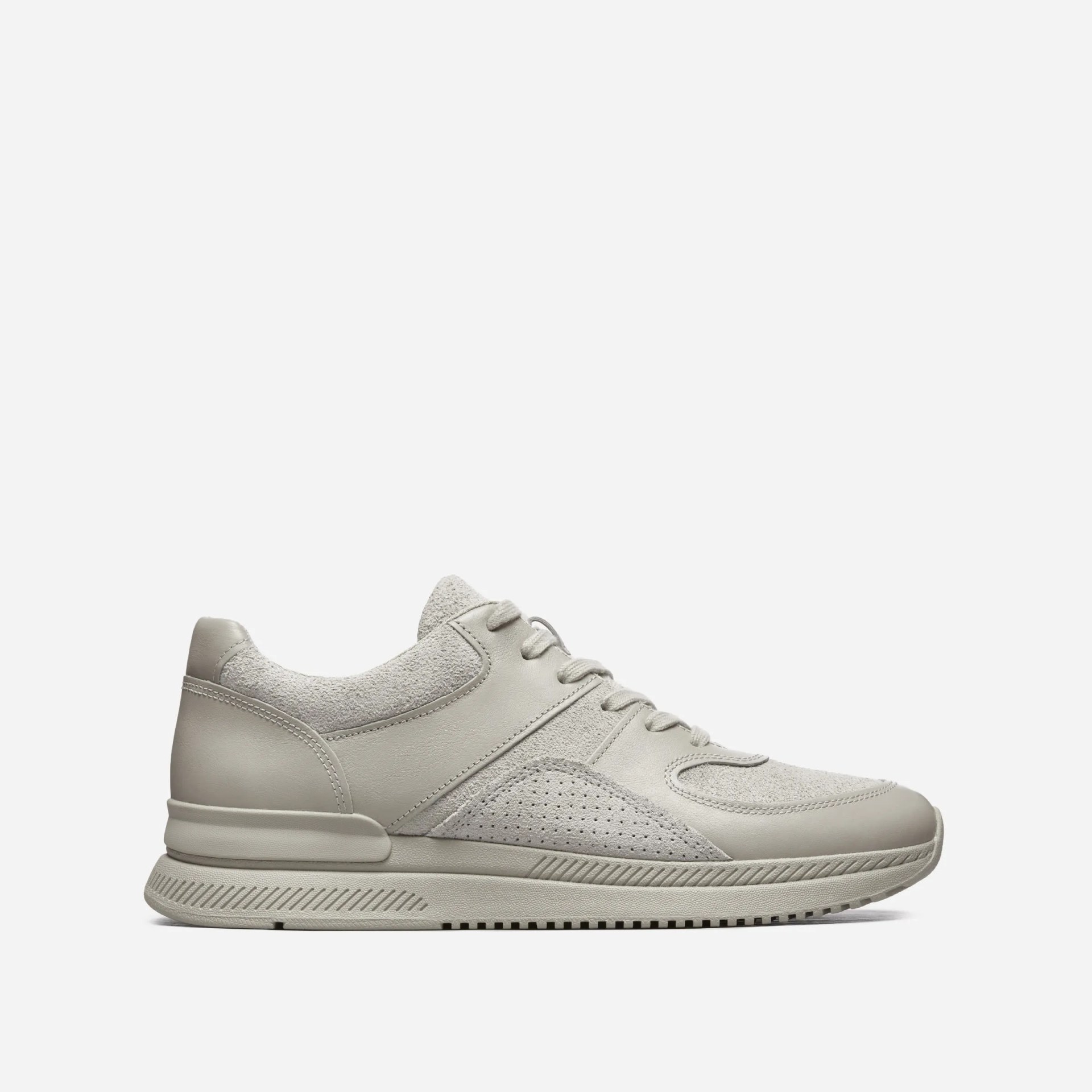 A grey sneaker on a grey background.