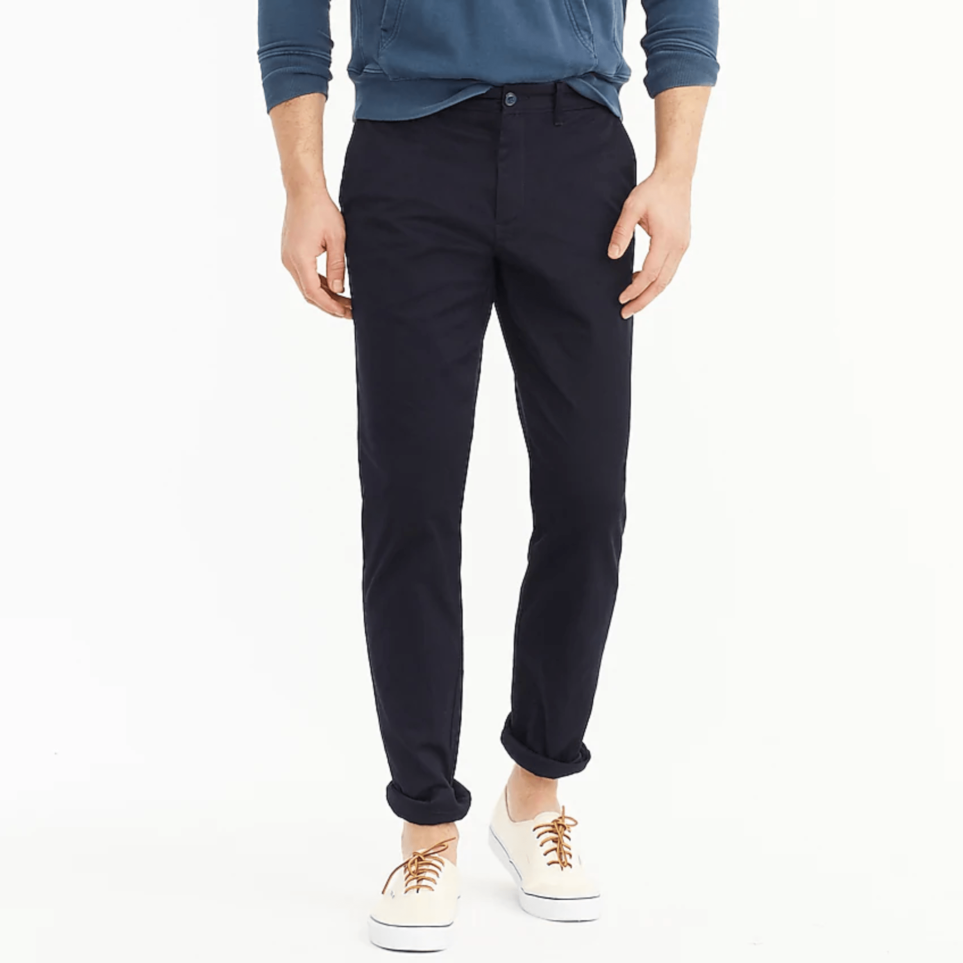 Blue chinos on a model with a blue sweatshirt and white sneakers on a gray background.