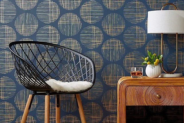 chair and night stand in front of blue wallpaper