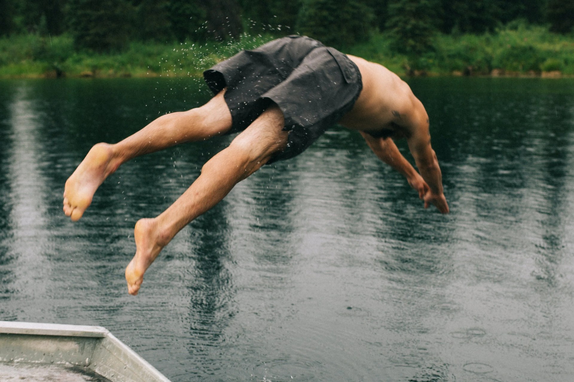 man jumping into a lake