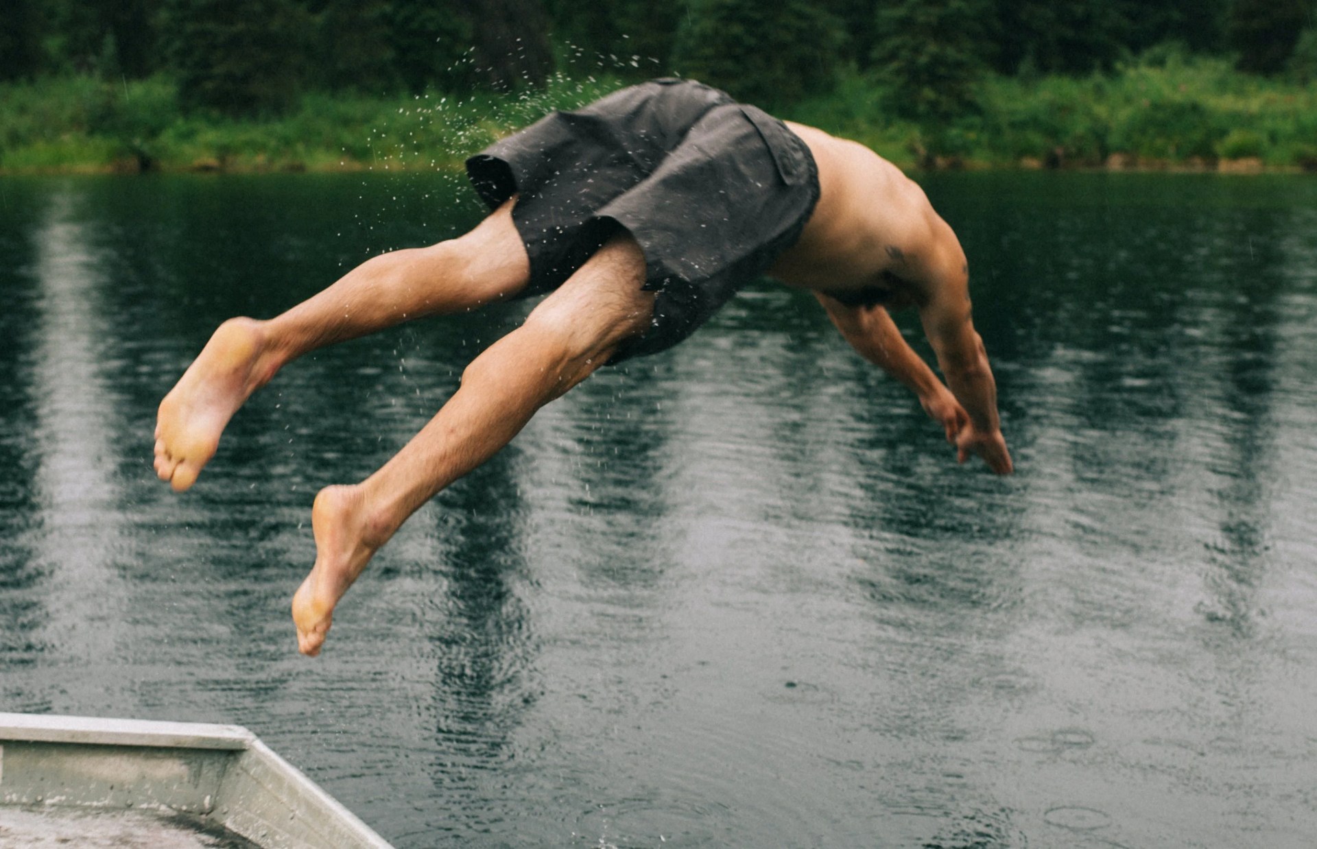 man jumping into a lake
