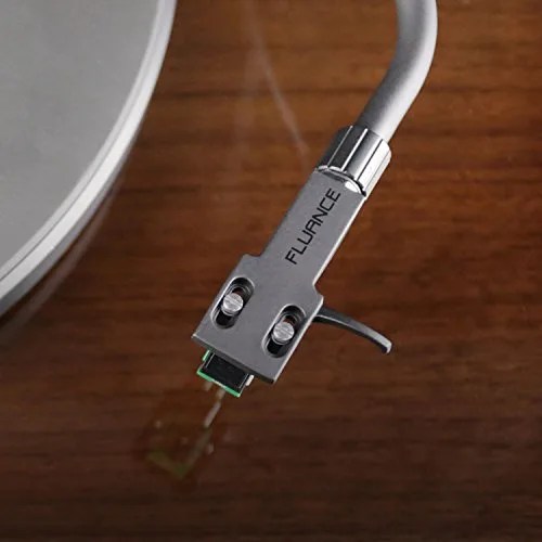 A closeup of a tonearm against a wooden background.