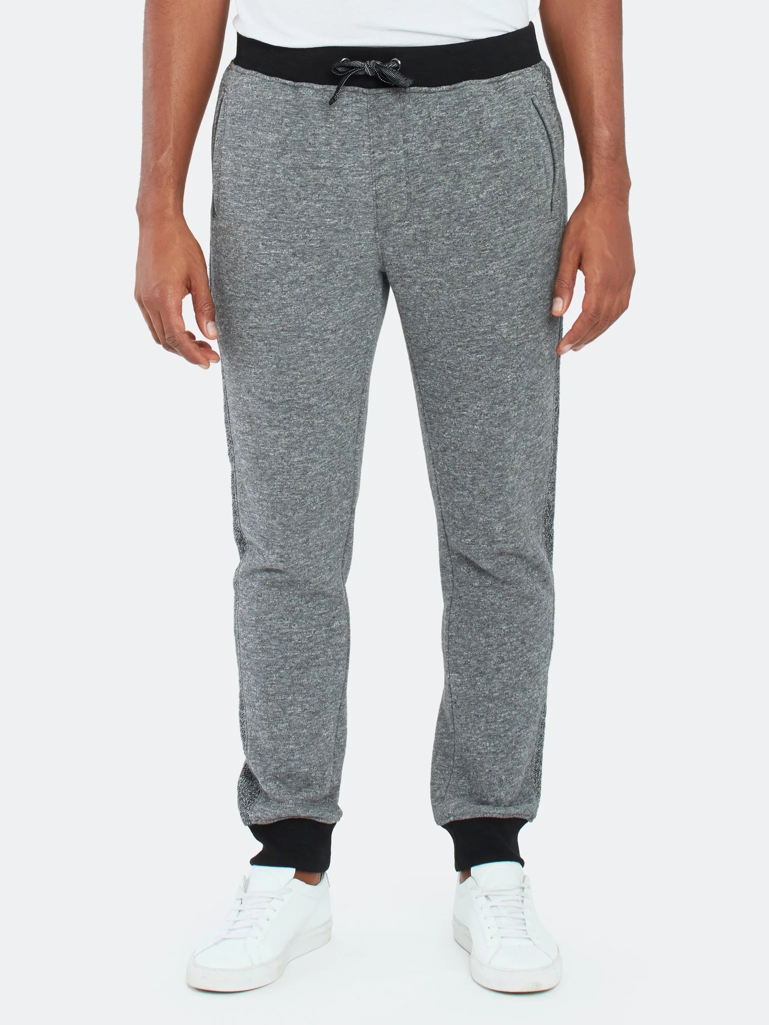 Gray and black joggers on a model on a gray background.