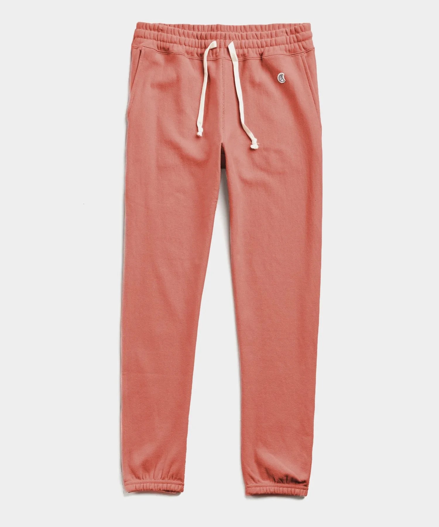 Orange sweatpants on a gray background.