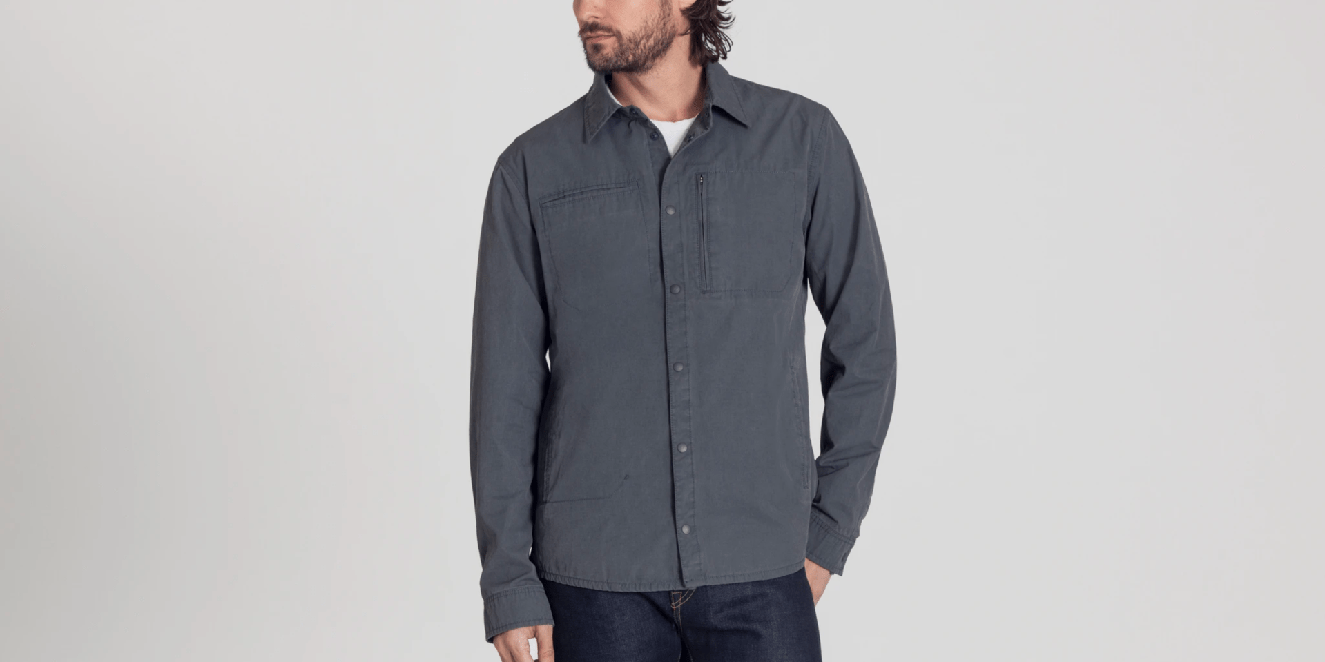 A model wearing a graphite jacket and jeans on a gray background.