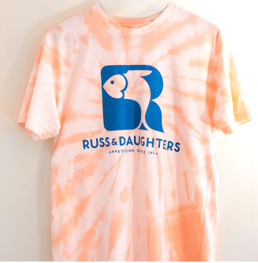orange tie-dye tee with "Russ & Daughters" text and logo