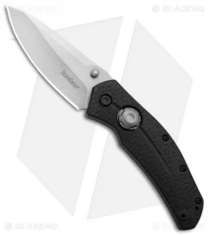 A black-handled folding knife on a white and gray background.