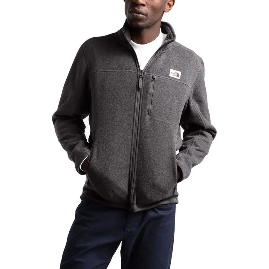 A model wearing a gray fleece zip-up jacket on a gray background.