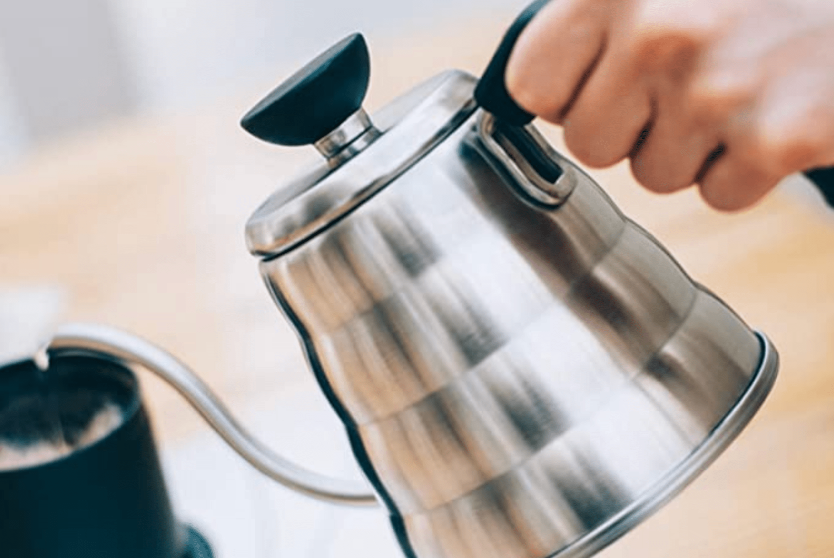 a stainless steel kettle being poured into a mug