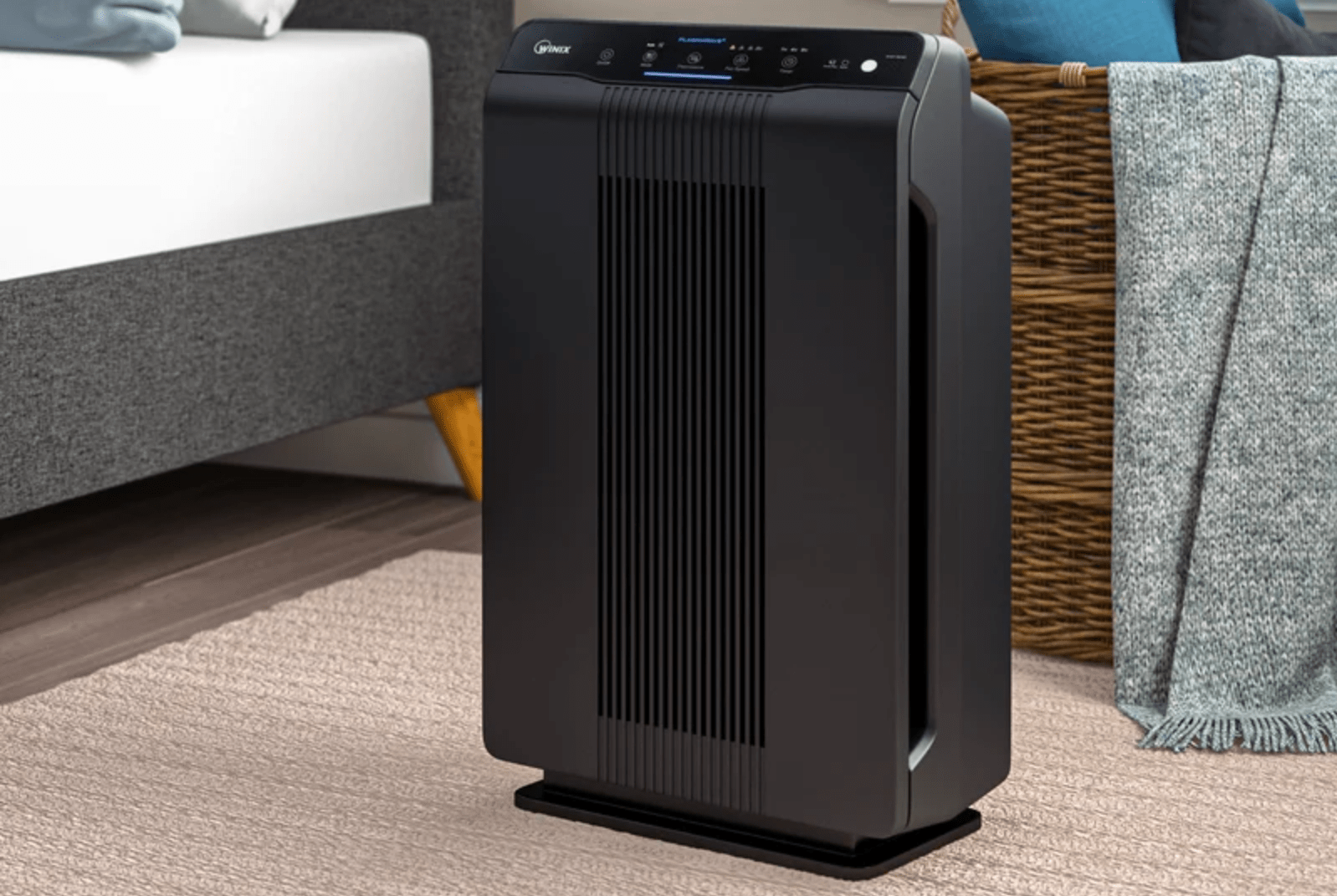 a black air purifier in a bedroom scene