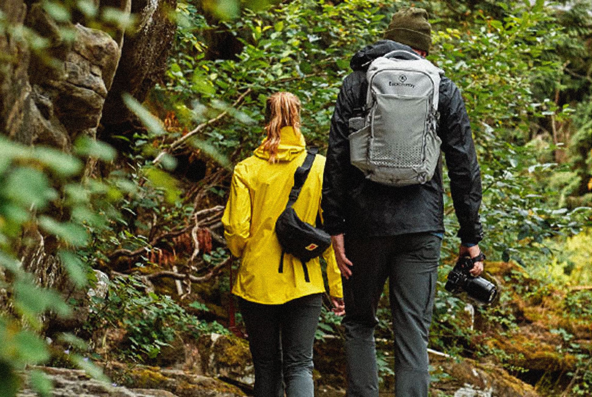 a man and woman walking in a forest
