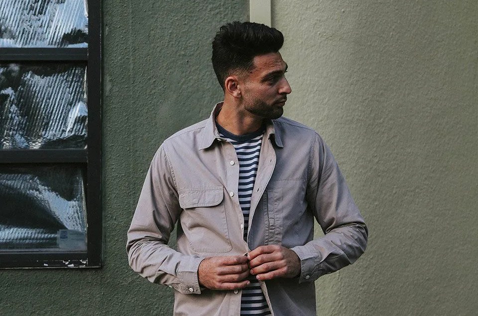 man buttoning shirt