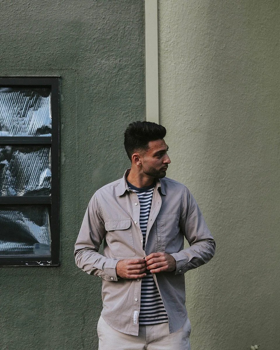 man buttoning shirt