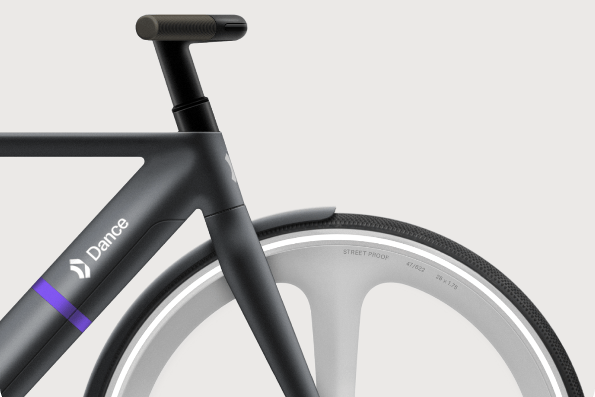 a close up of a black bike's handlebars and wheel