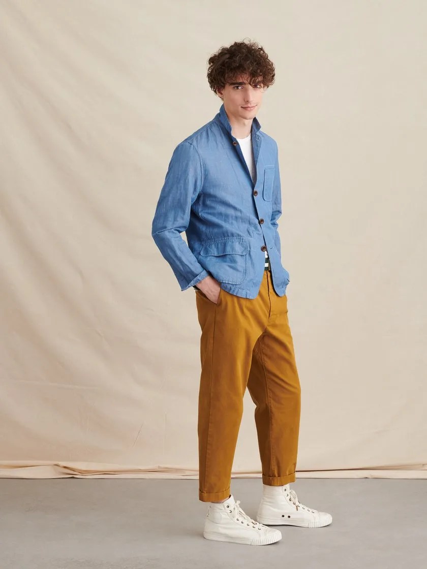 A model wearing a linen blazer, white t-shirt and caramel pants.