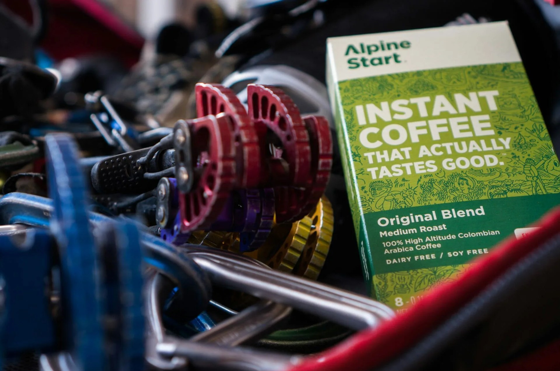 a box of instant coffee next to climbing gear