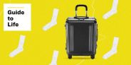black rolling suitcase against yellow background