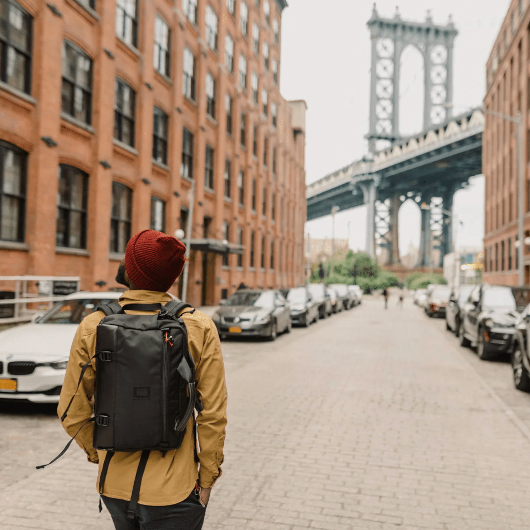 a model walking down a street in brooklyn towards the manhattan bridge