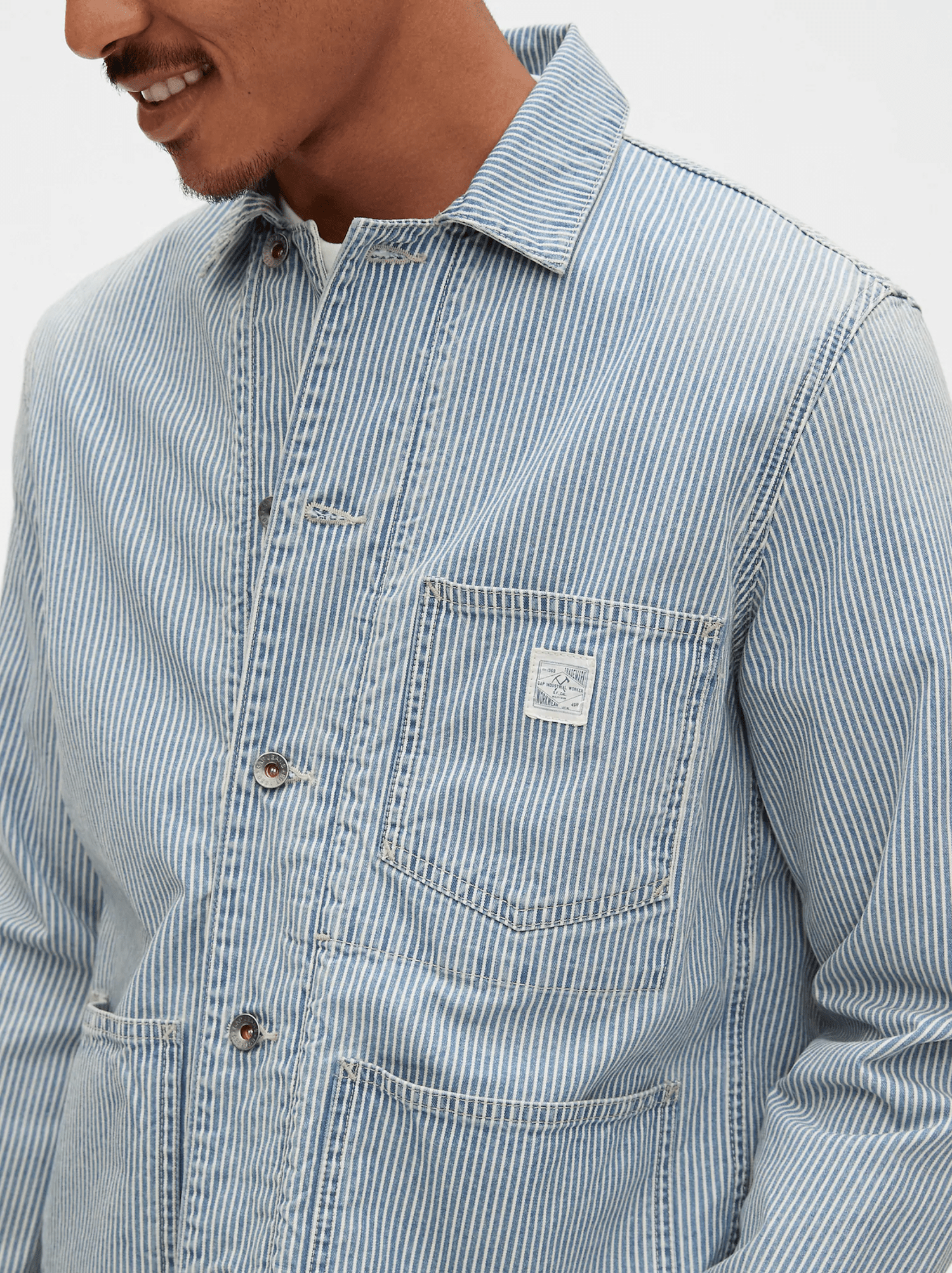 a model wearing a blue railroad stripe chore jacket
