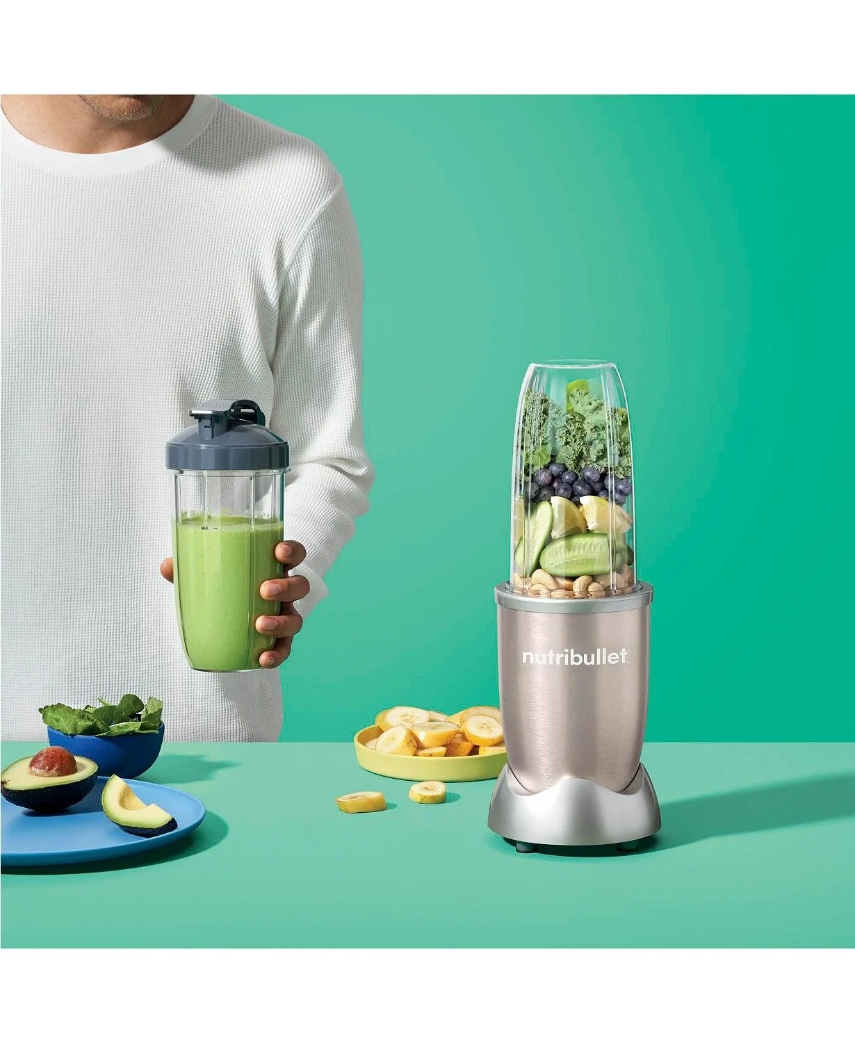 a male model blending up smoothies with fruits and vegetables