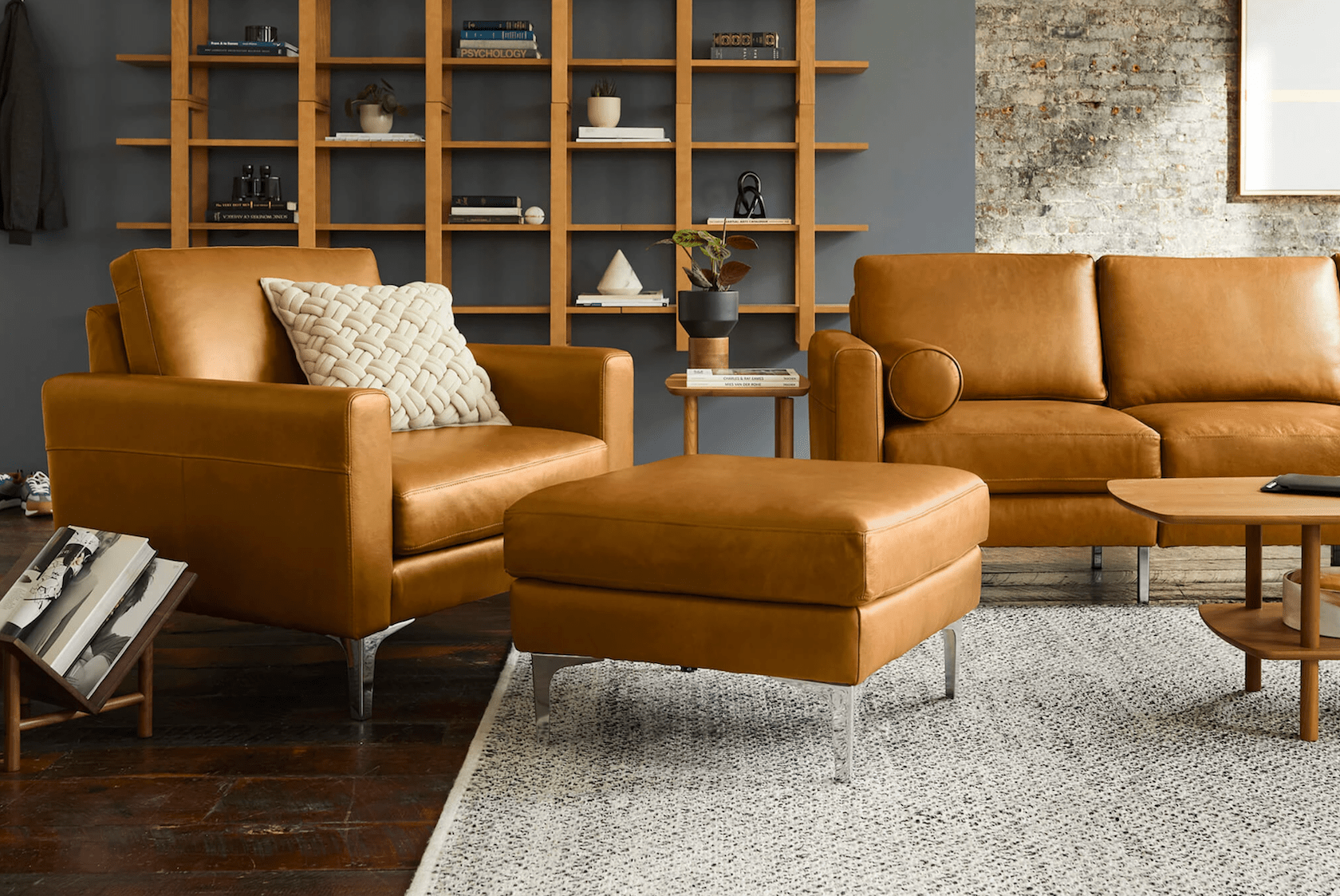 a living room scene with brown leather couch, chair and ottoman