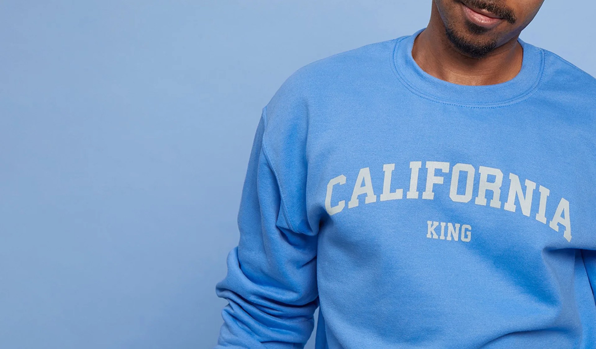 man wearing blue sweatshirt that says california king