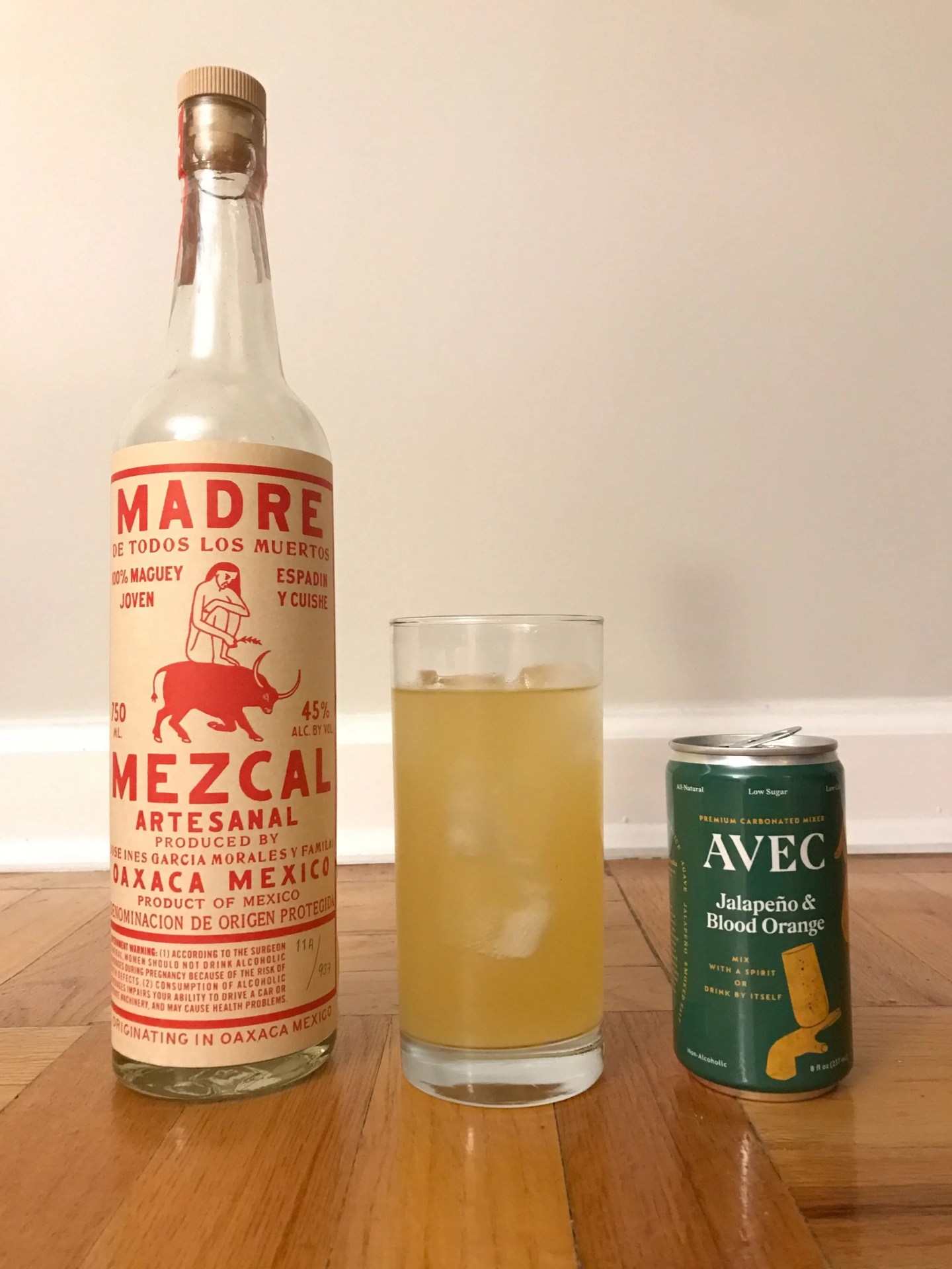 bottle of mezcal, can of avec and glass filled with liquid